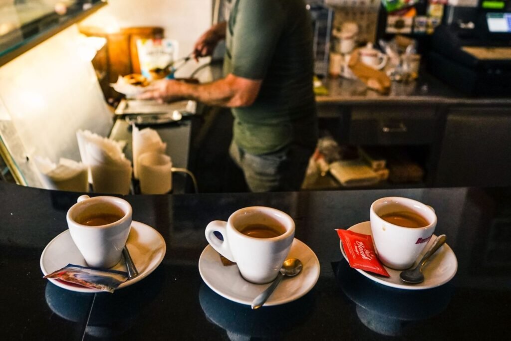 Espresso cups on a cafe counter with a barista working behind