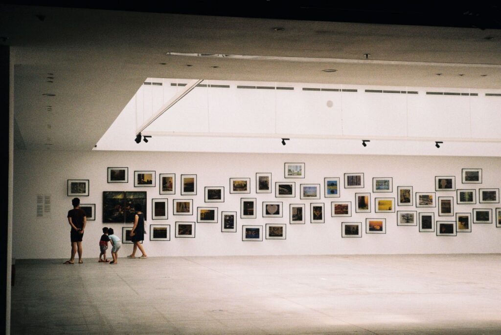 A bright gallery hung with a grid of small framed prints