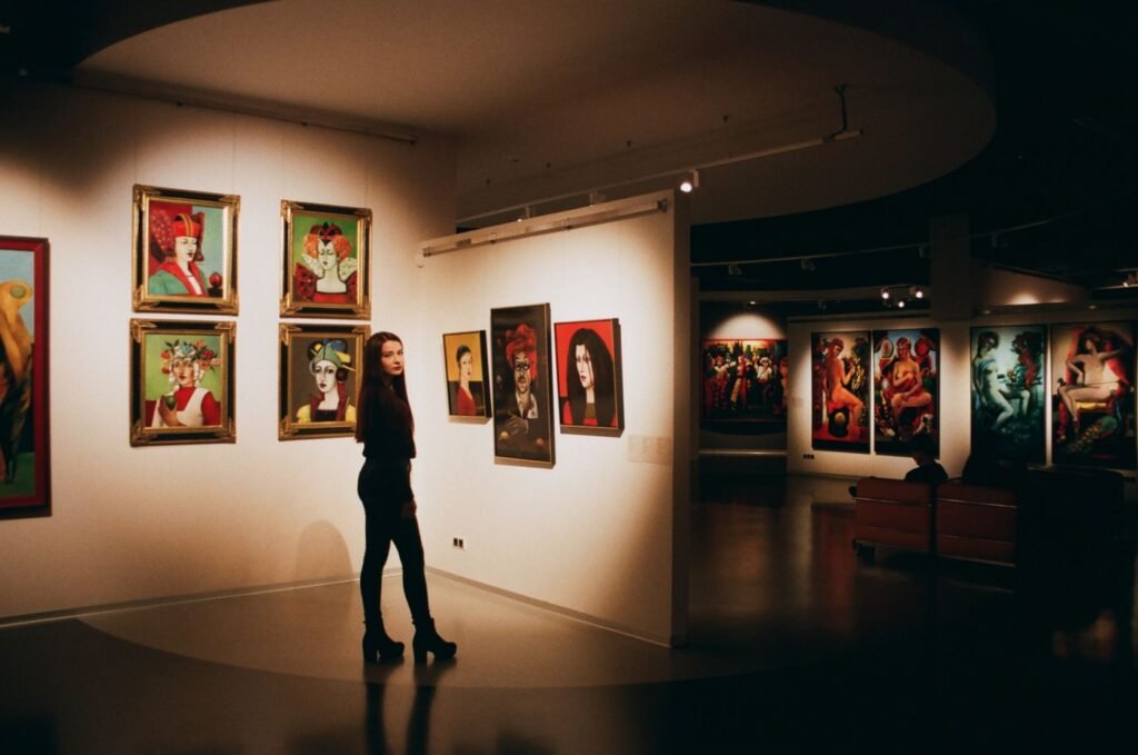 A visitor looking at framed pictures in a gallery