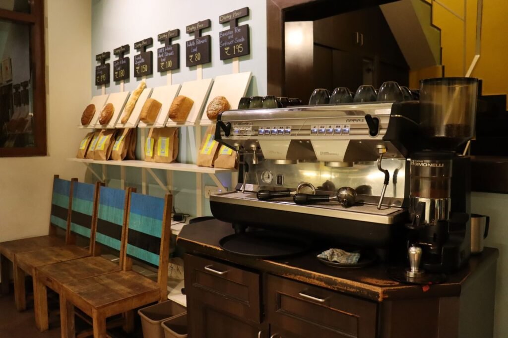 An espresso machine and bags of beans behind a cafe counter