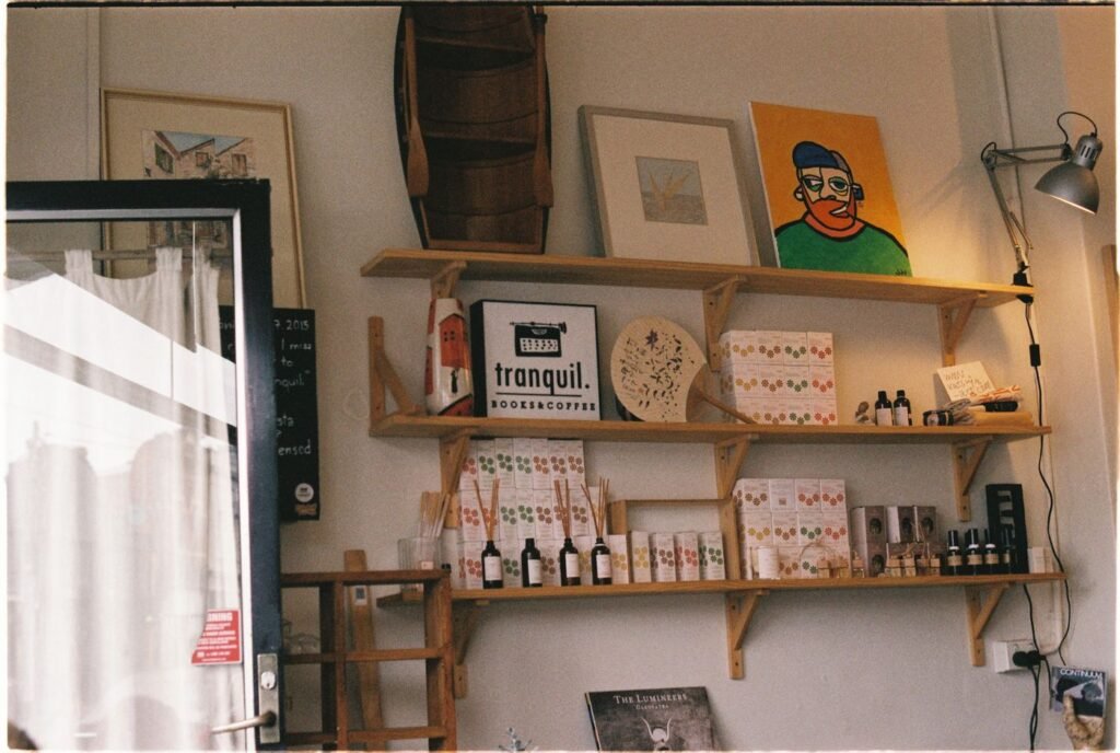 A pale minimal cafe interior with shelves and prints