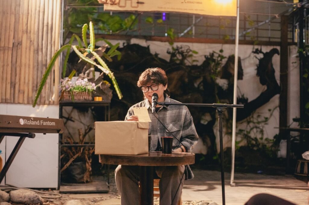 A poet reading into a microphone at a small venue