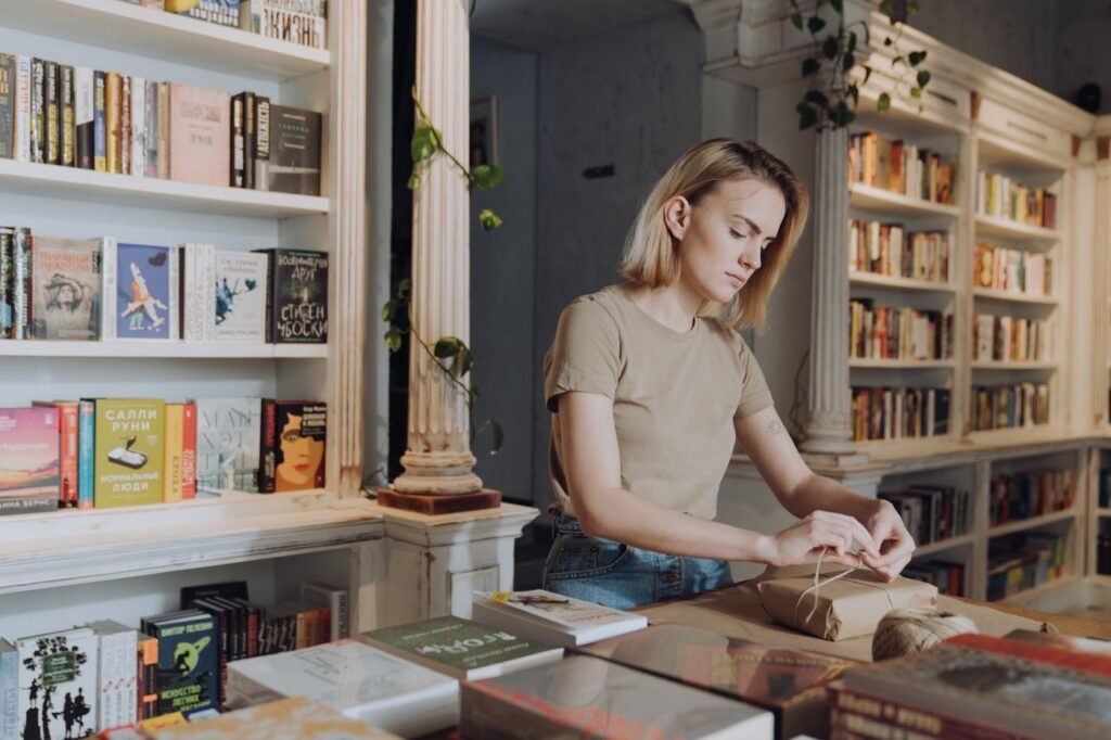 A bookseller behind the counter of a small shop