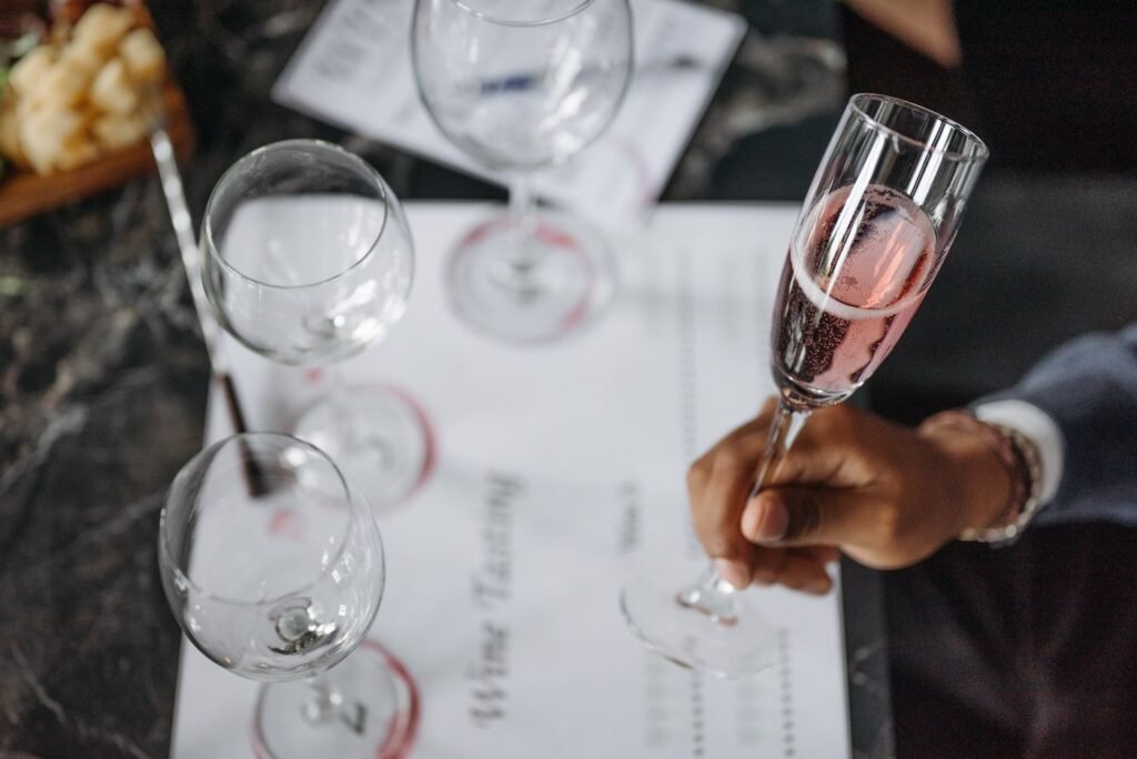 A hand holding a glass of sparkling wine at a tasting