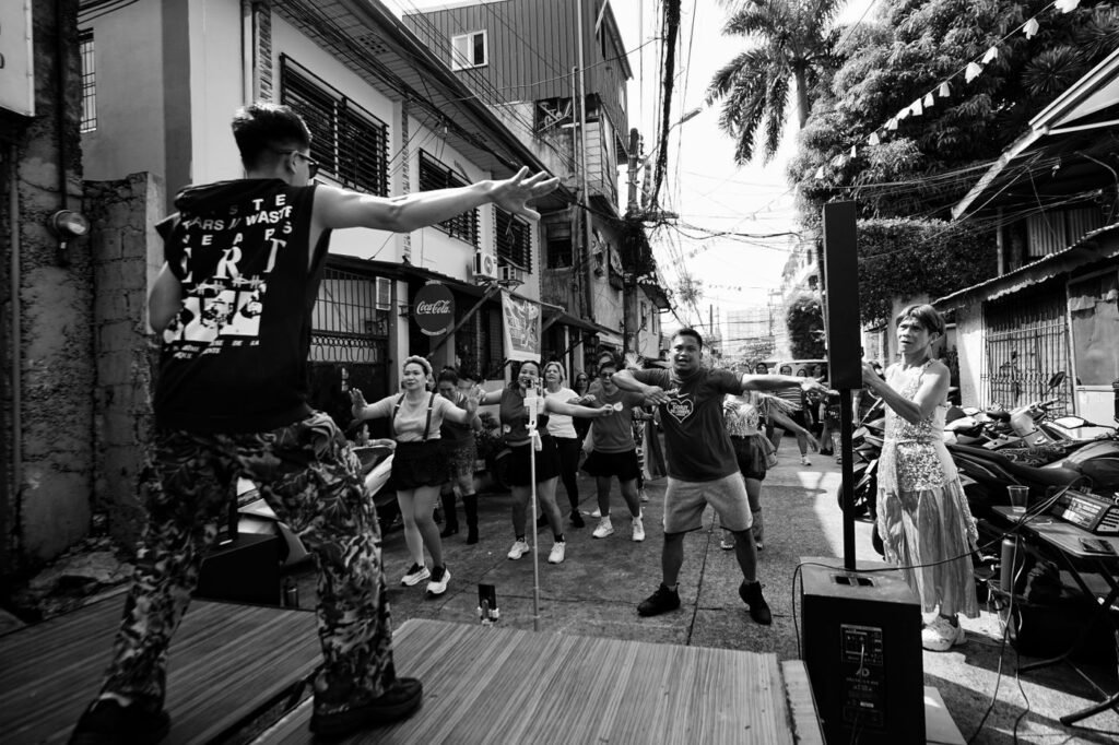Adults taking part in an outdoor street dance class in a city plaza