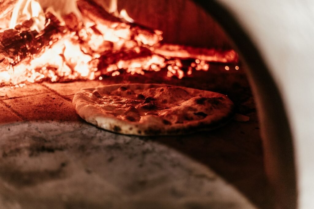 A pizza baking in a wood-fired oven