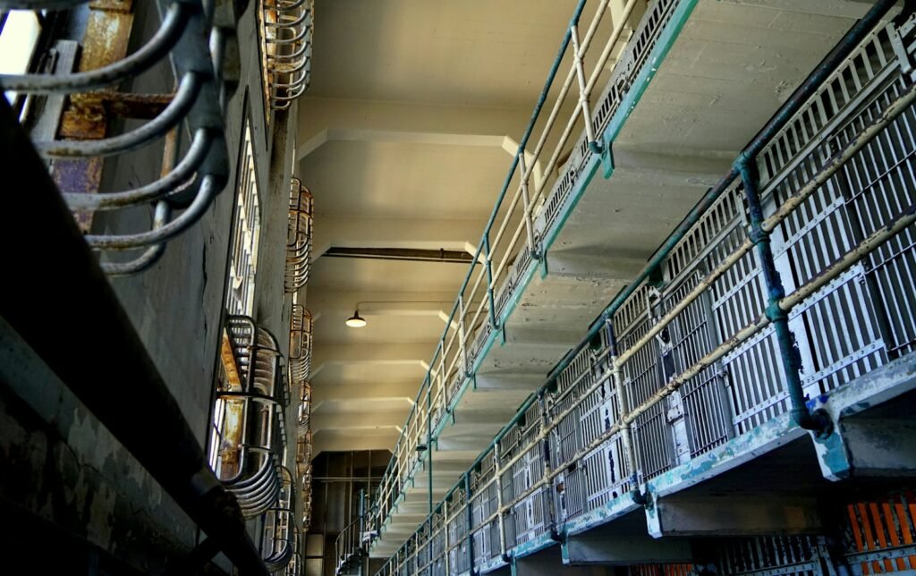 Looking up the tiers of cell doors inside the Alcatraz cellhouse, with a light hanging from the ceiling