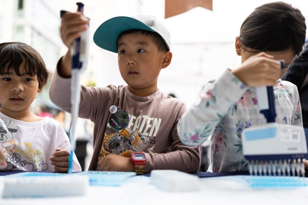 Kids using lab pipettes at the Bay Area Science Festival