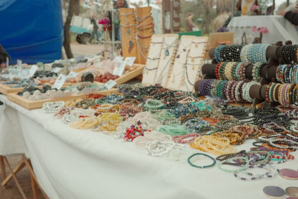 A table covered with colorful handmade bracelets and necklaces at a market stall
