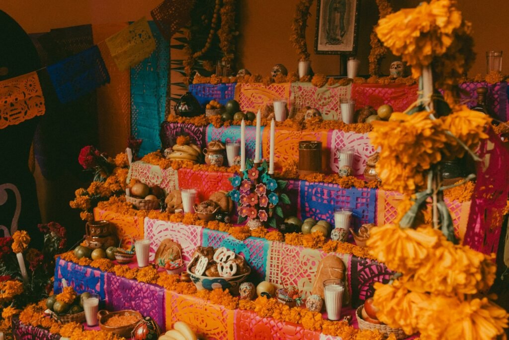 An ofrenda for Día de los Muertos with marigolds, candles, sugar skulls and decorations