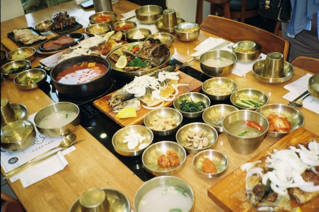 A table laid with Korean dishes and brass side-dish bowls.
