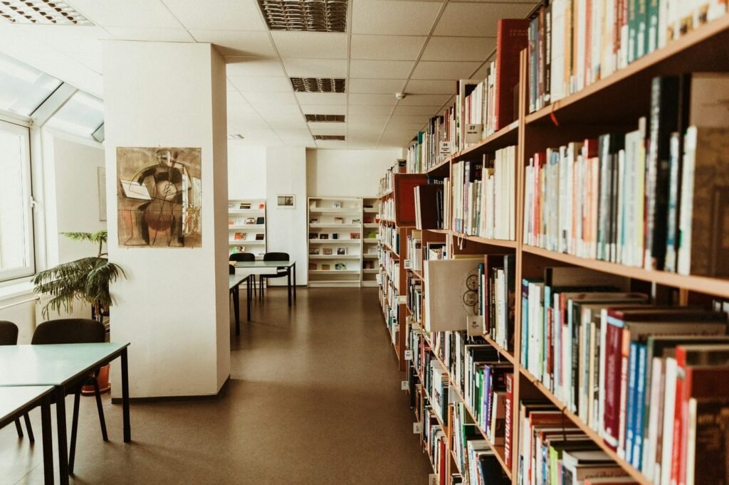 A bright library room with wooden bookshelves and study tables