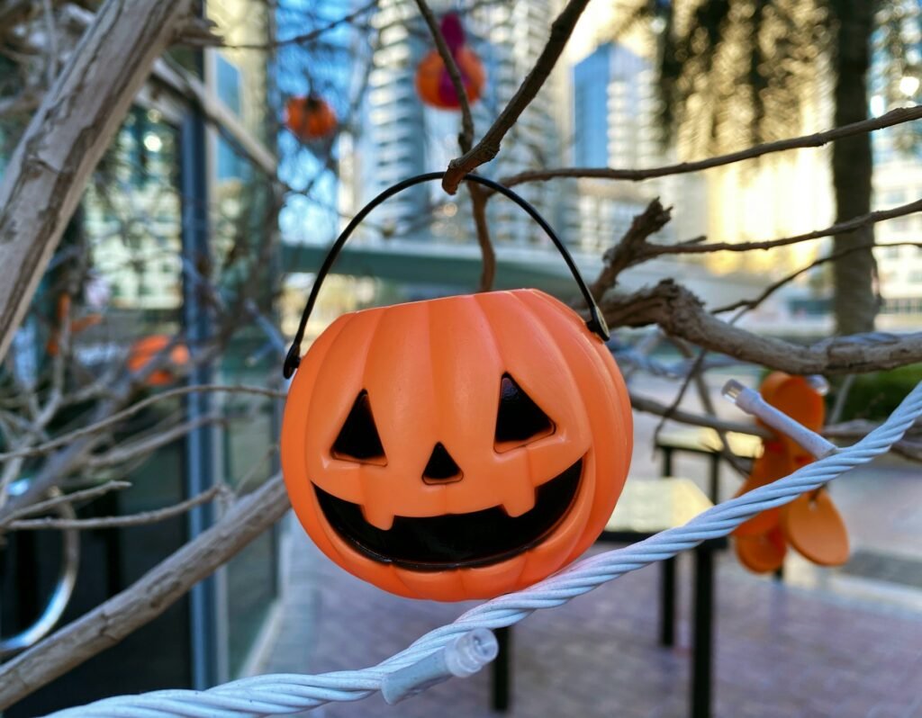 A Halloween pumpkin hanging from a rope in the city