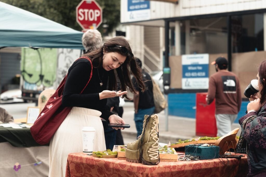 A shopper looks over handmade pieces on a vendor table at the Inner Sunset Flea Market on Irving Street