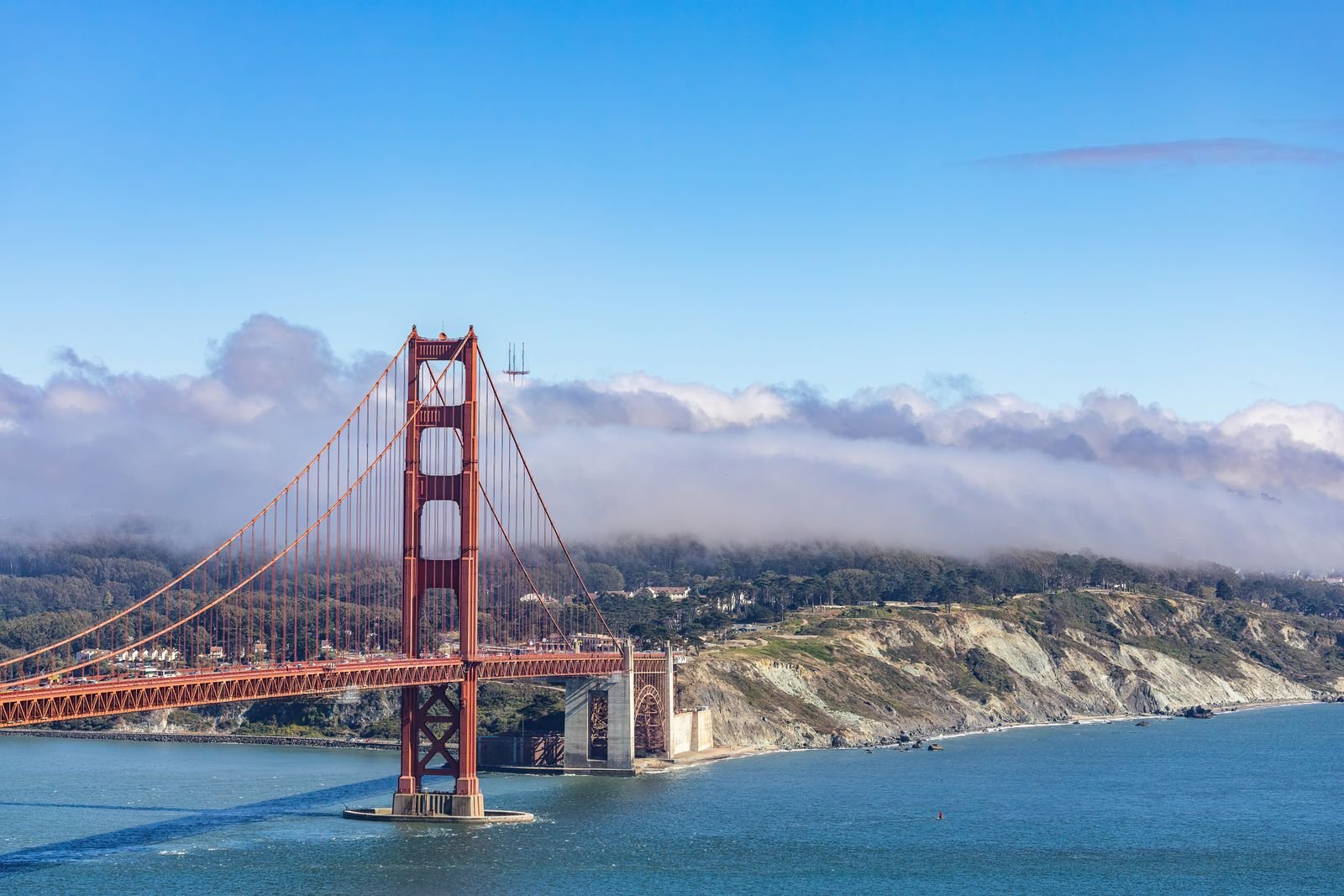 The Golden Gate Bridge with fog banked over the headlands.