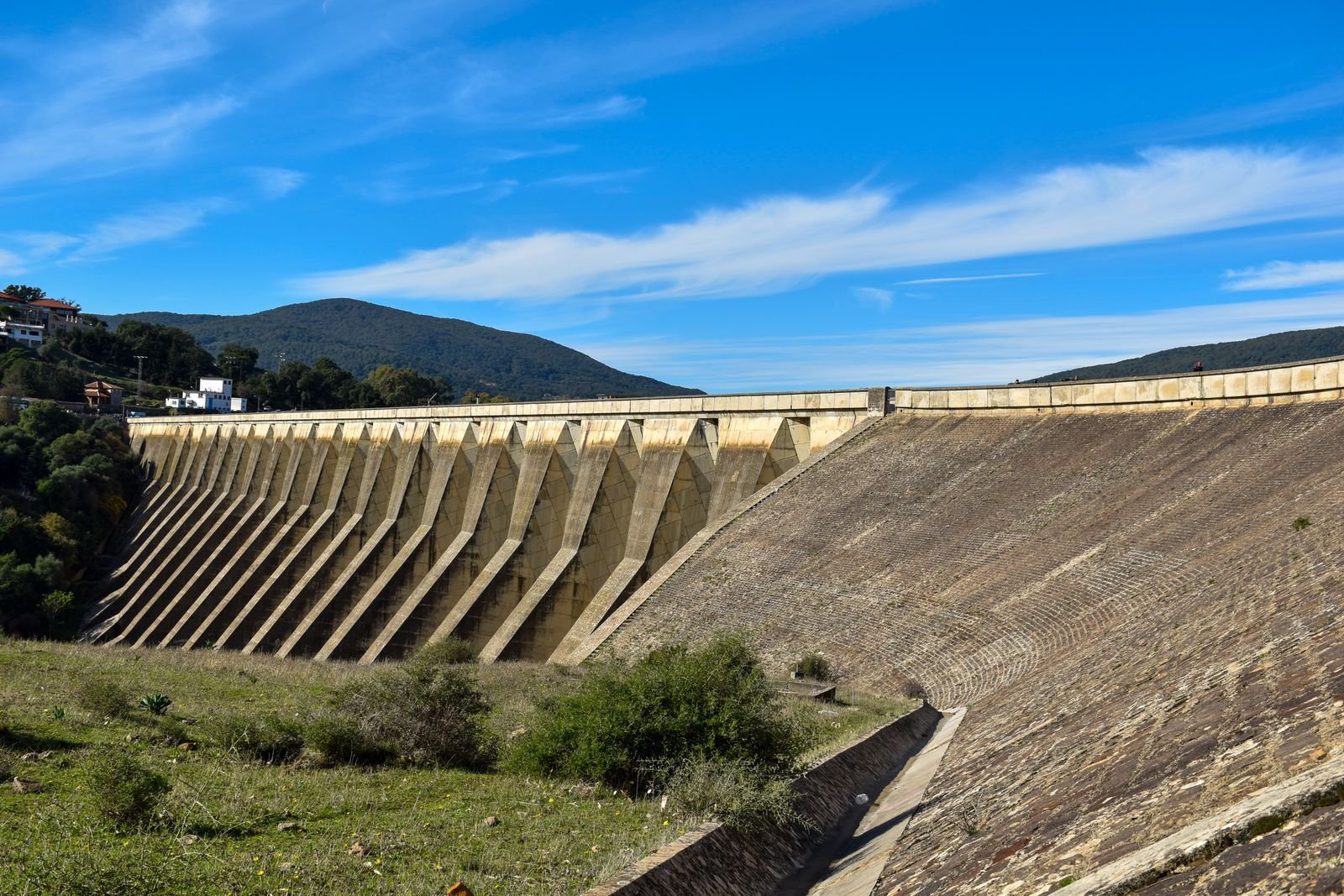 A large concrete dam against a clear sky.