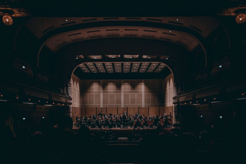 An orchestra playing a symphony on the stage of a large theater.
