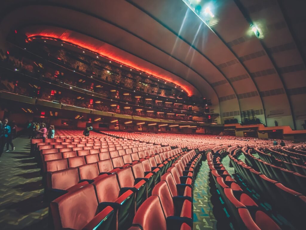 Rows of red seats in a theater auditorium.