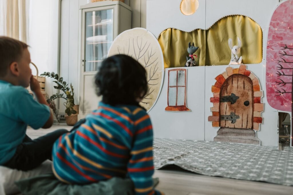 Children watching a puppet theater show indoors.