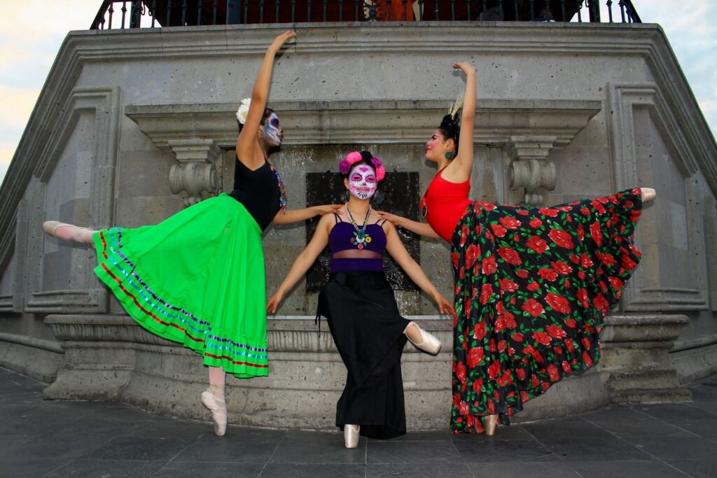 Dancers in colorful Día de los Muertos costumes and face paint.