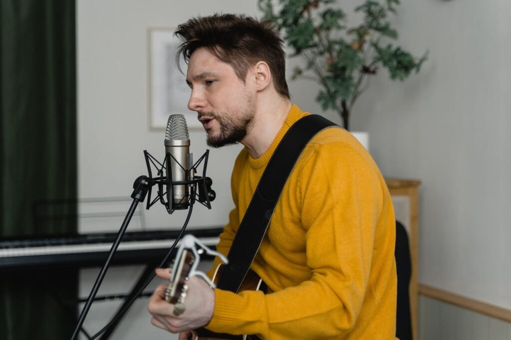 A man singing and playing an acoustic guitar.