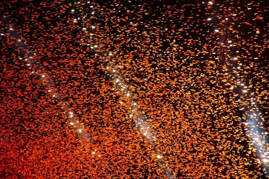 Orange confetti falling against a dark background.