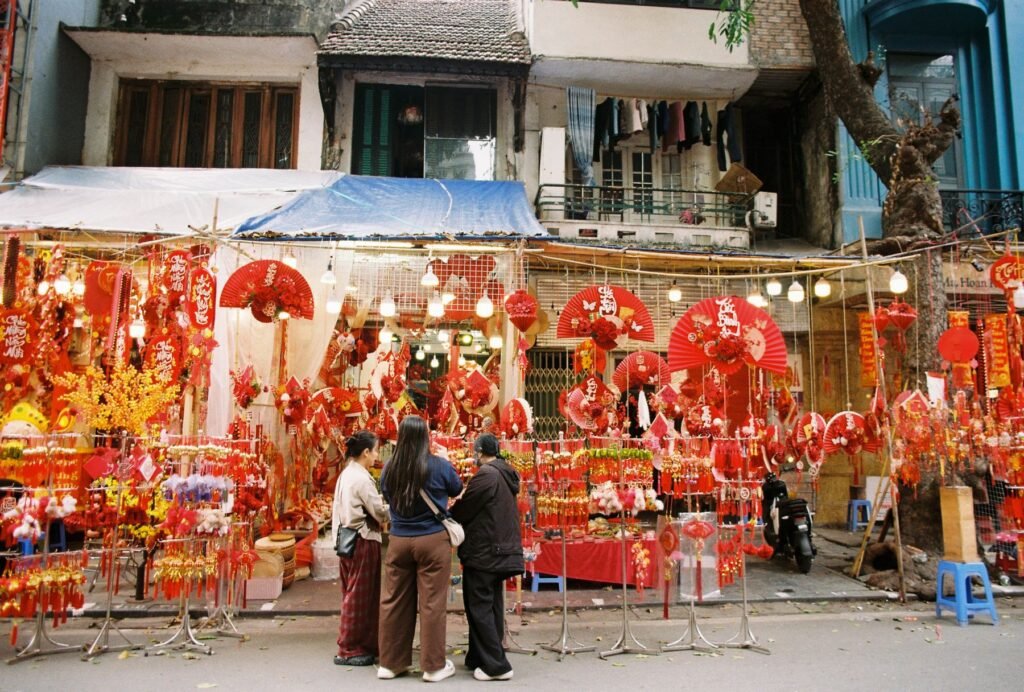 A busy street market hung with red lanterns.