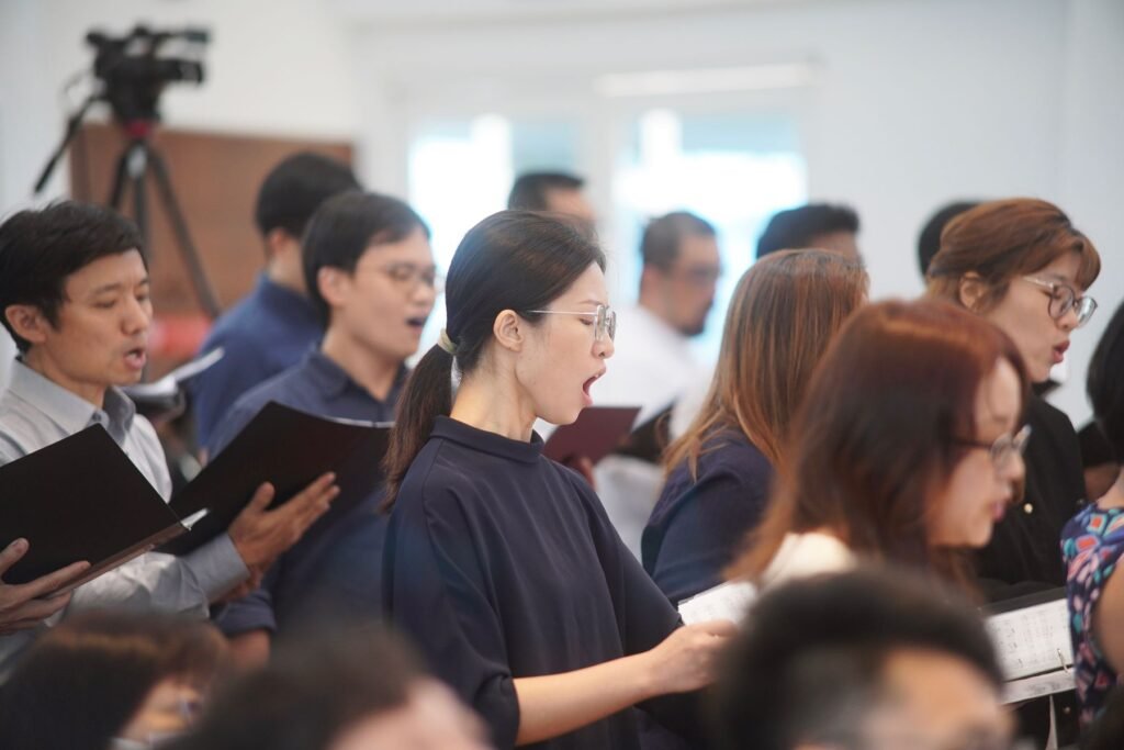 A choir singing from song books.