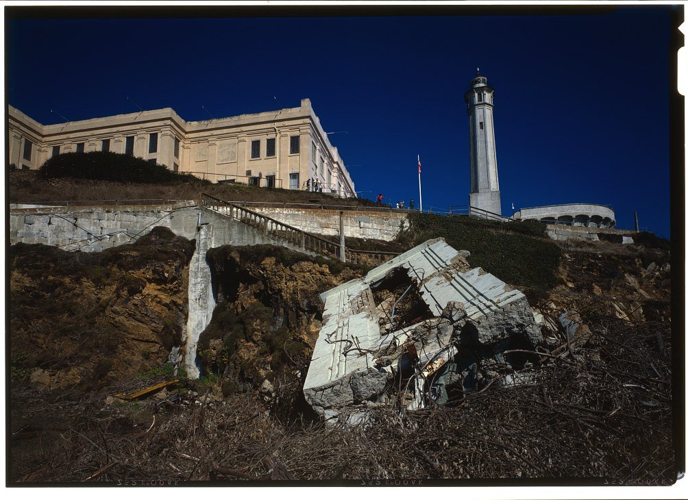 The Alcatraz cellhouse and lighthouse on the island seen from below the rocks