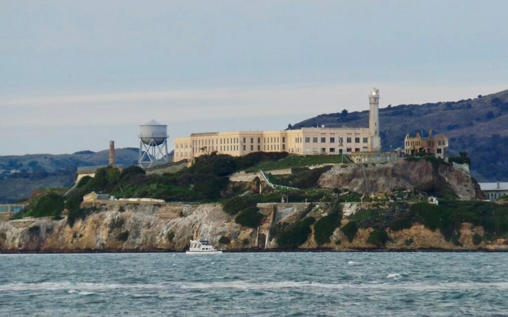 Alcatraz Island with its prison buildings and water tower, seen from the bay