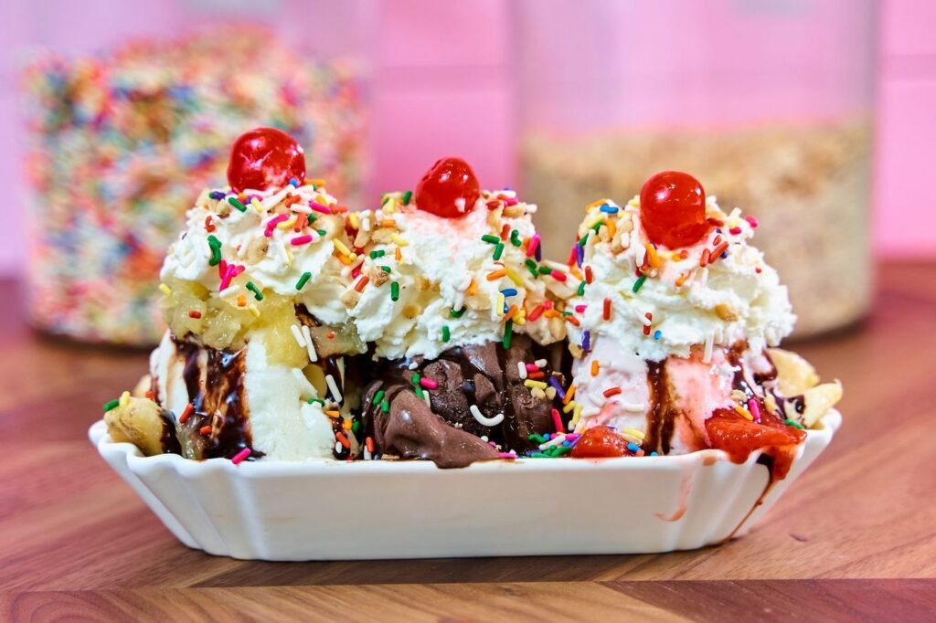 Banana split sundae with whipped cream, cherries and sprinkles