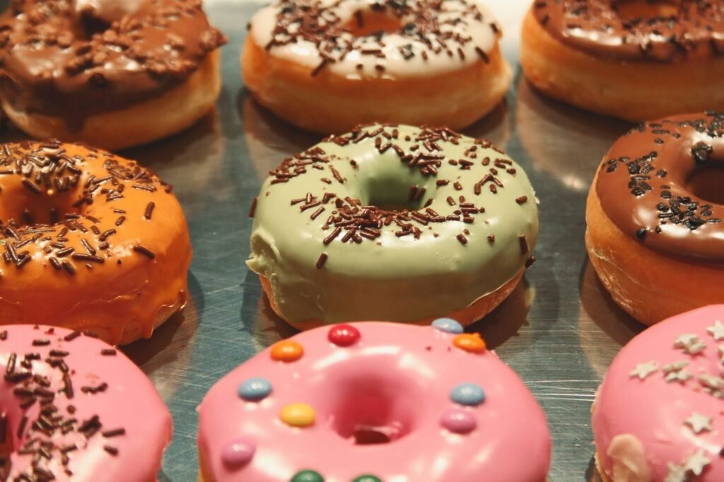 Tray of colorful glazed and sprinkled donuts
