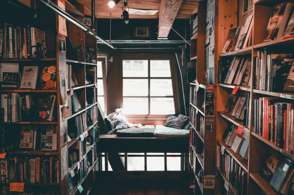 Cozy bookstore nook with a window seat between tall bookshelves