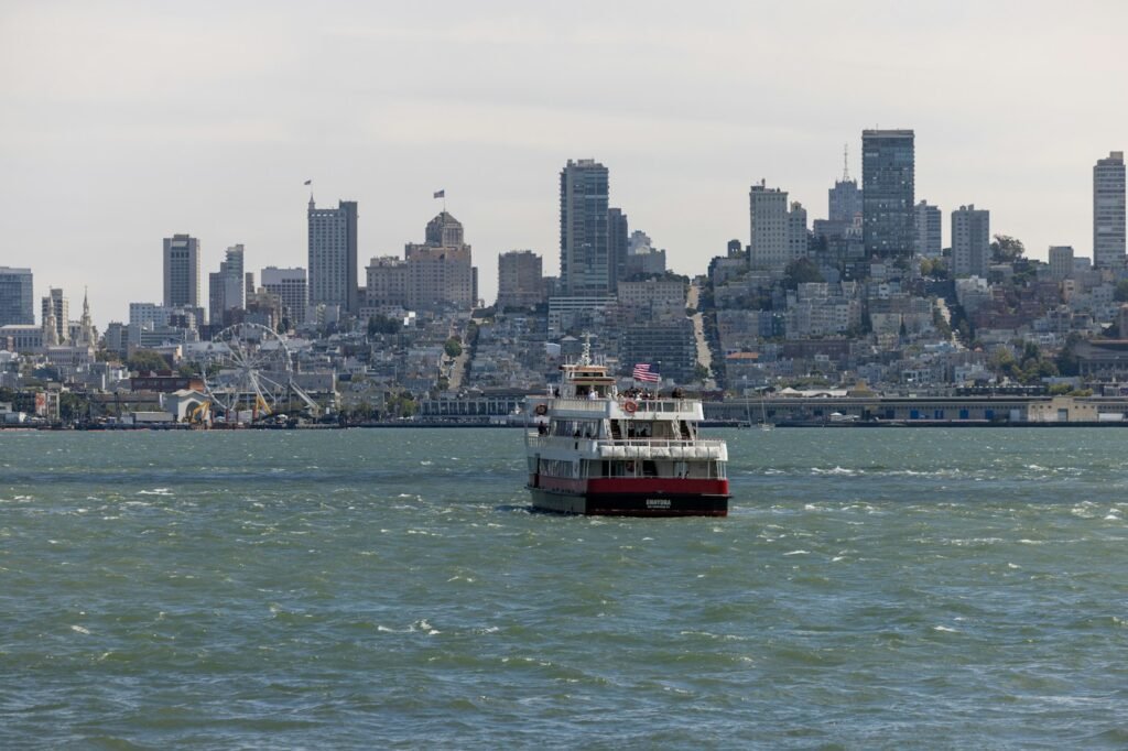 A passenger ferry crossing San Francisco Bay with the city skyline behind it