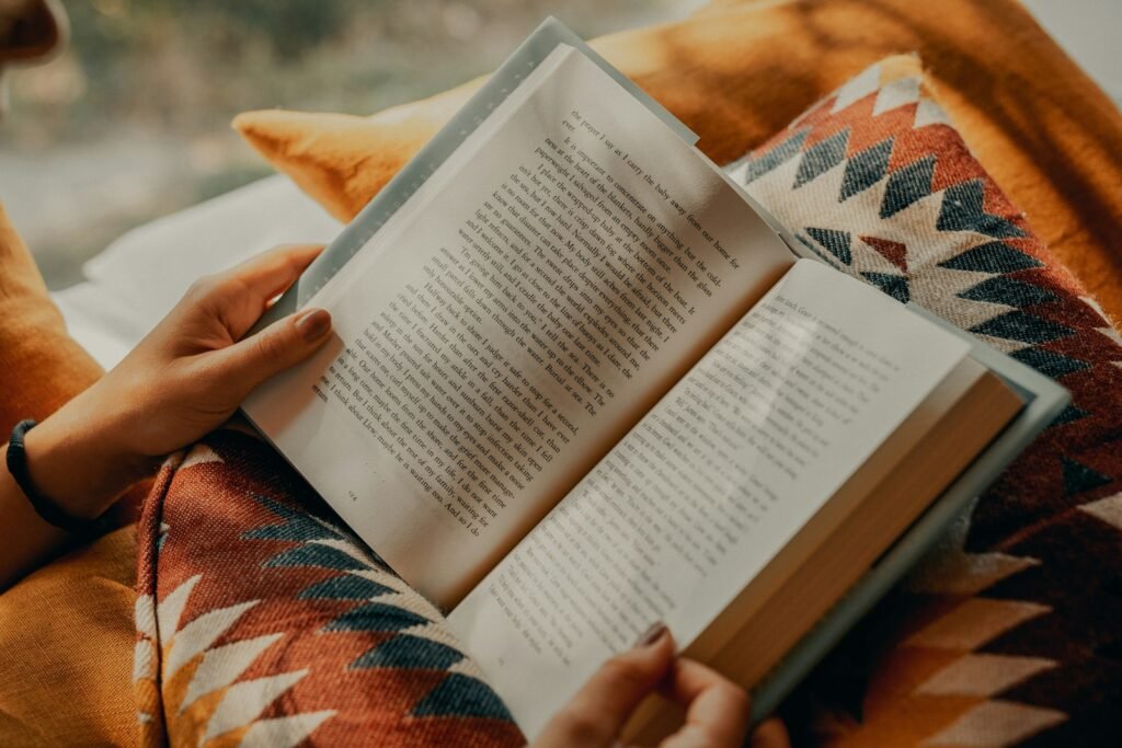A person reading an open paperback book