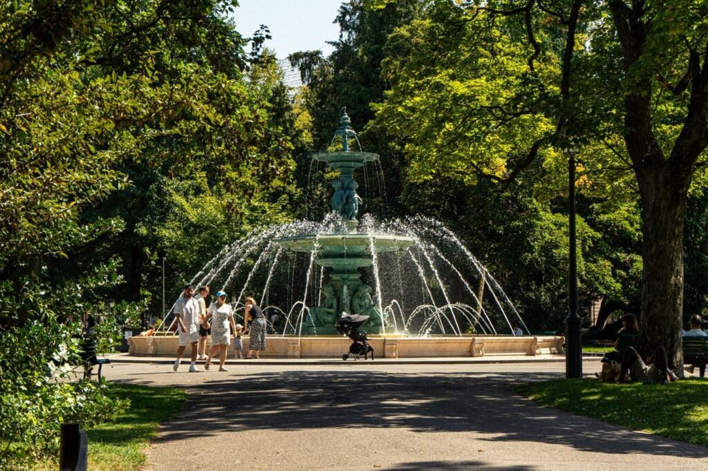 Ornate fountain in a formal tree-lined city park