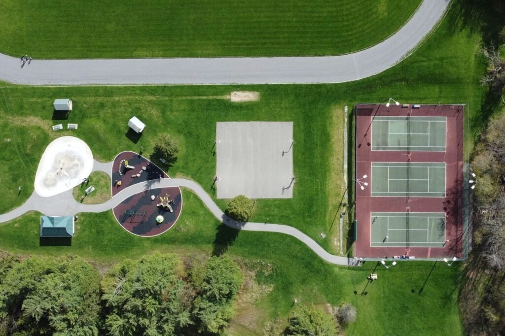 Aerial view of a park with a playground beside tennis courts