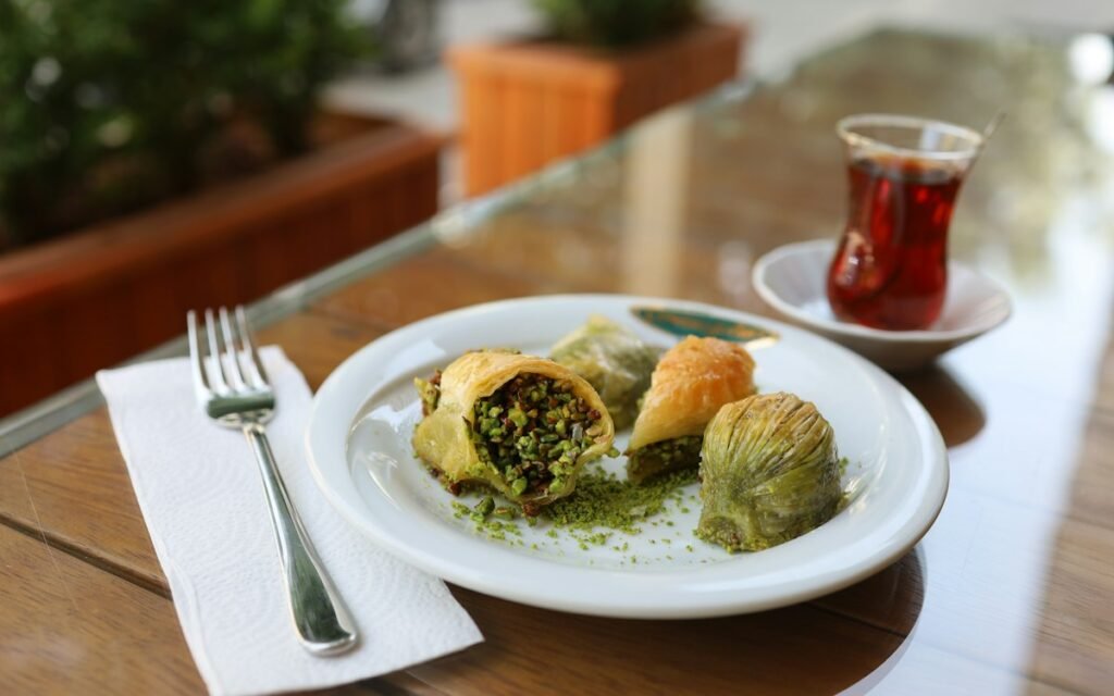 Turkish tea in a tulip glass beside a plate of baklava