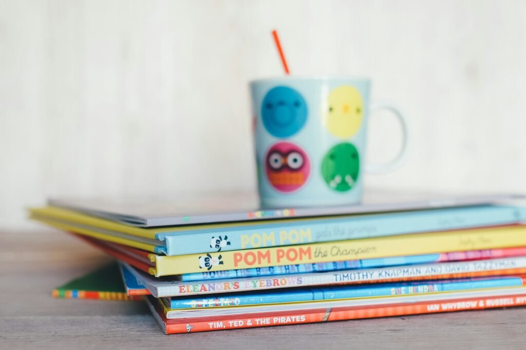 A stack of children's picture books with a cheerful mug on top